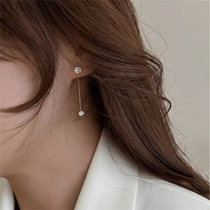 Alvora Delora gold drop earrings with twin solitaire stones on fine chains, minimal design